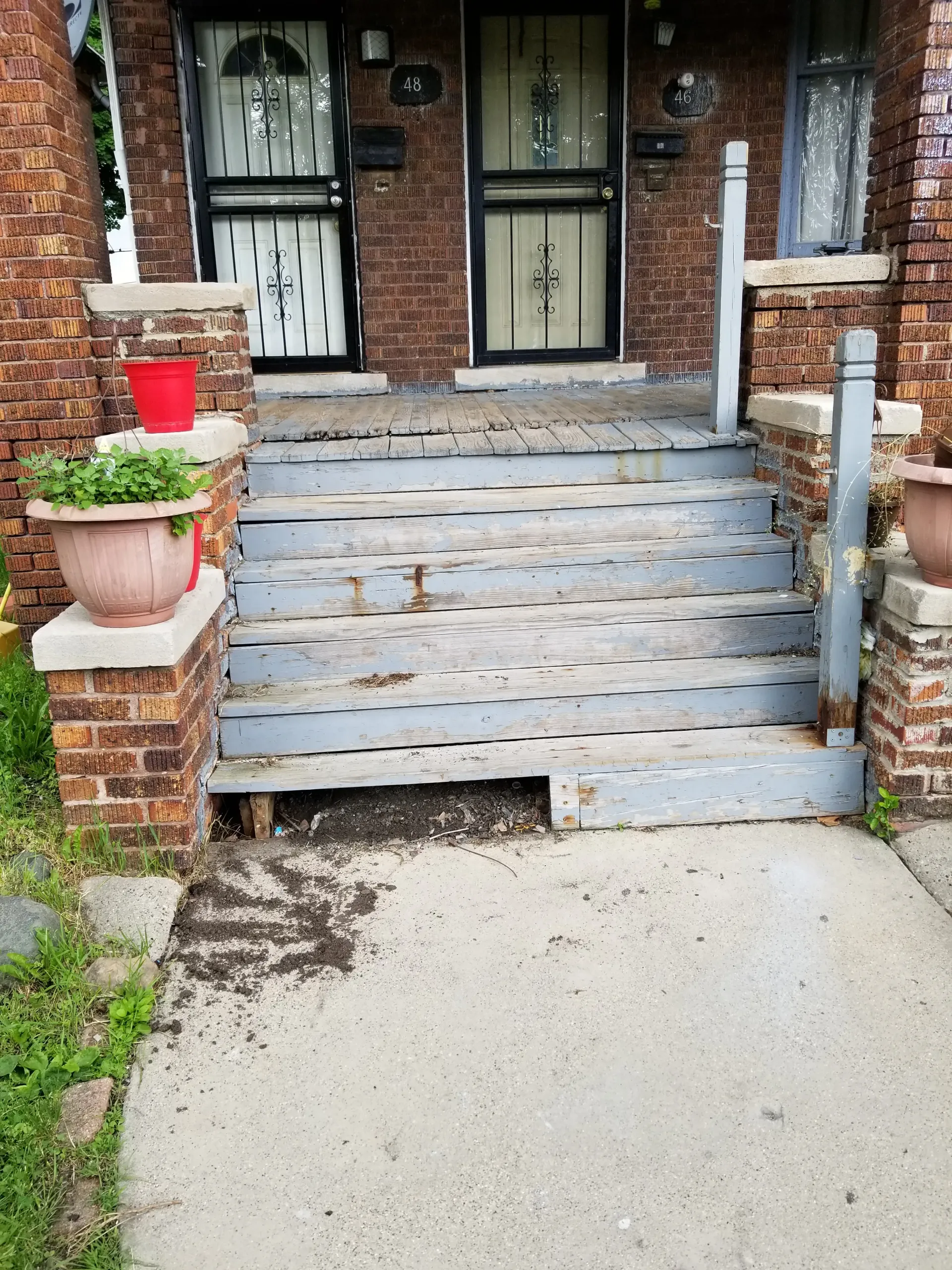 Weathered front steps leading to a brick building with two doors