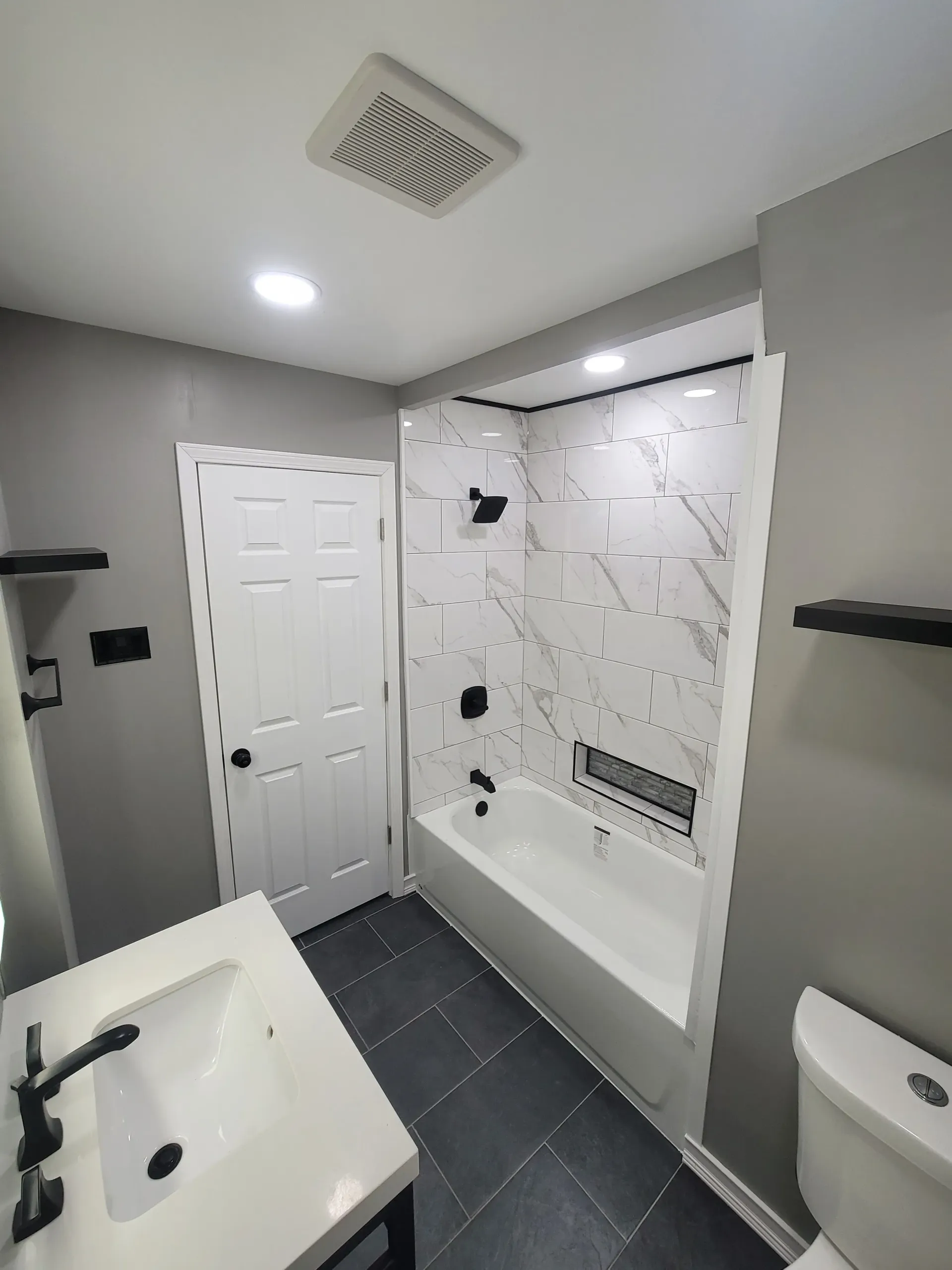 Newly renovated bathroom with gray wall and white marble-look tiled