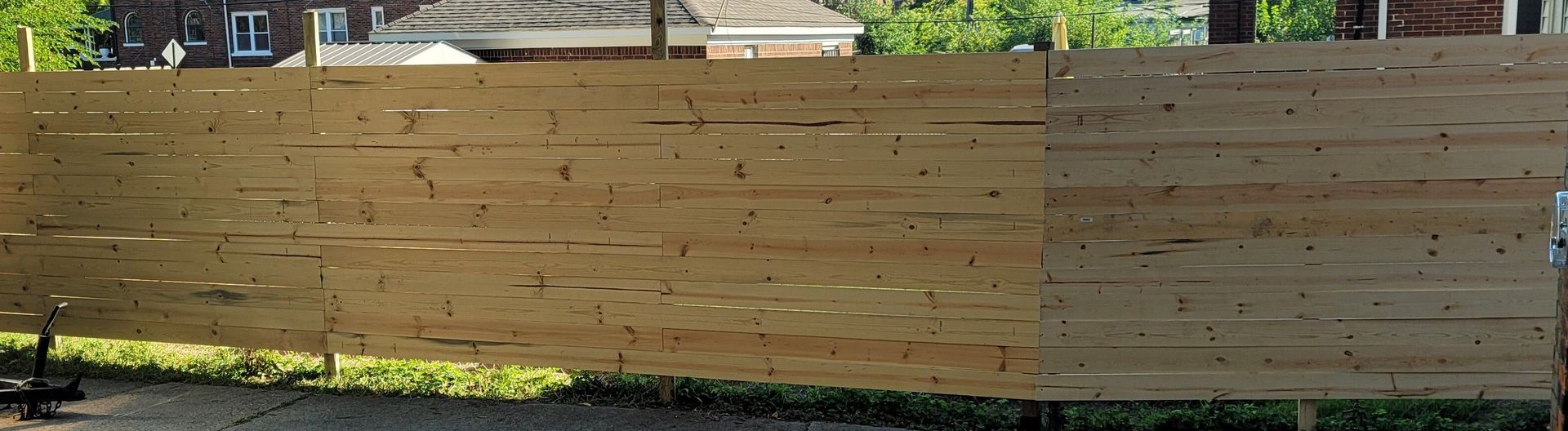 A long wooden fence, likely newly built