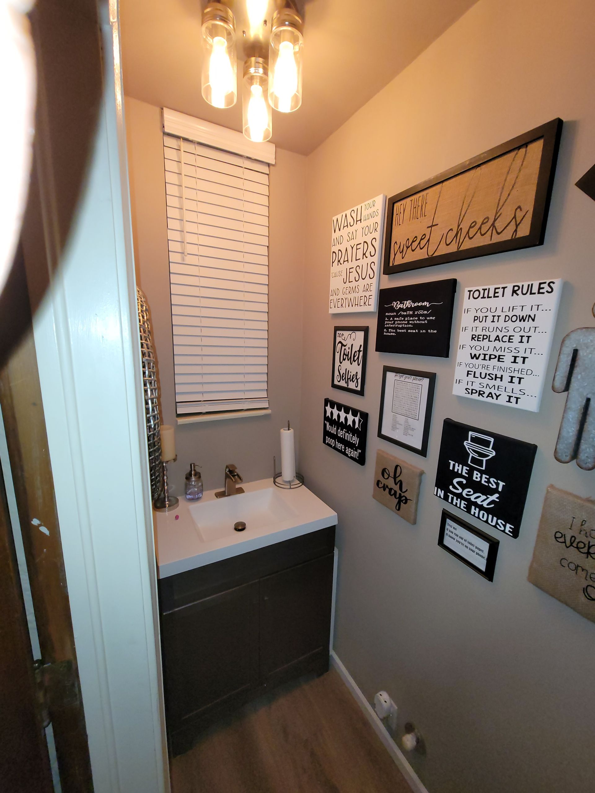 Bathroom with a sink and signs on the wall