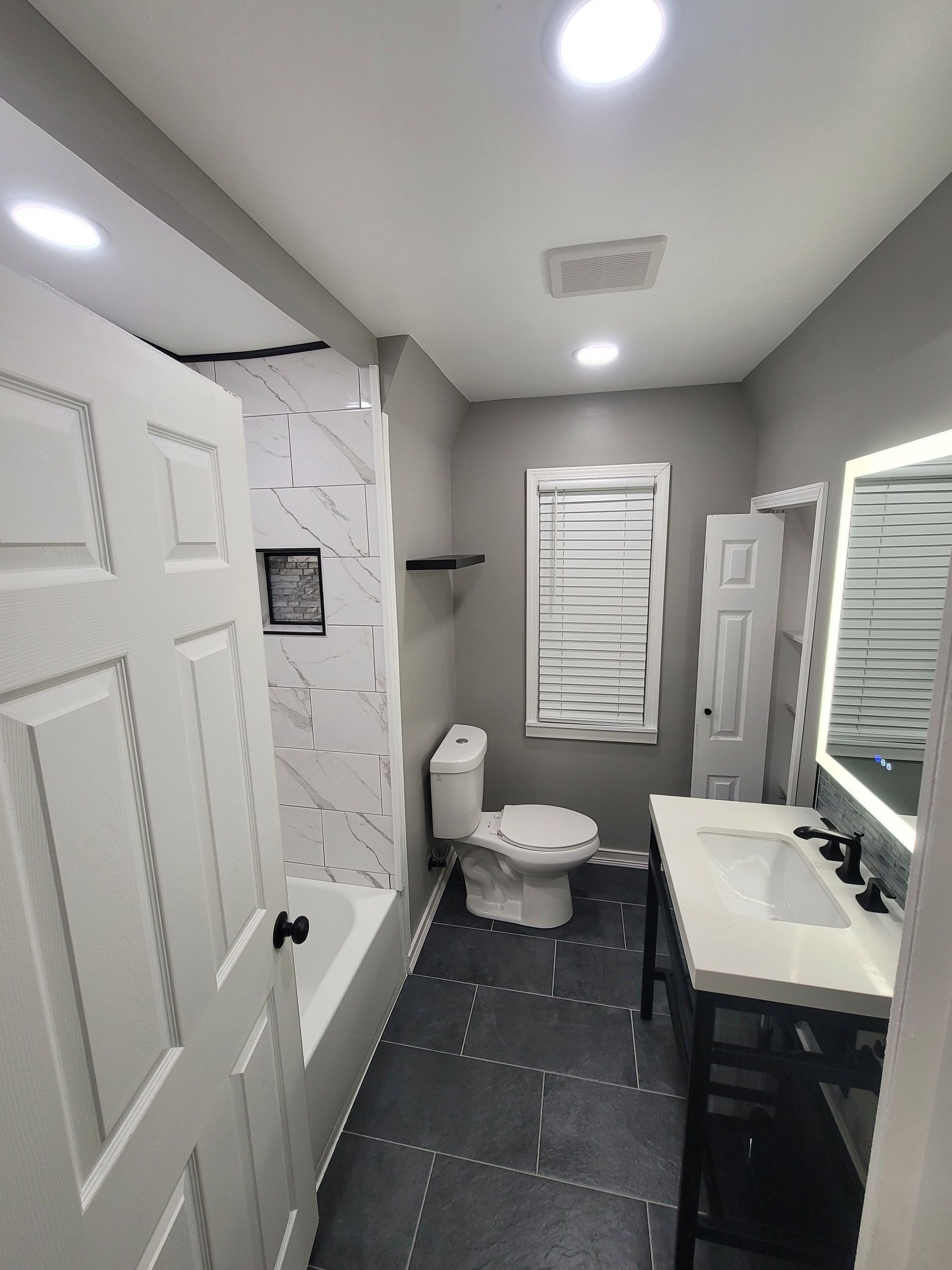 A renovated bathroom with white trim