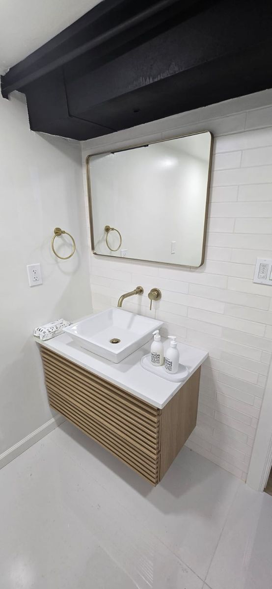 A modern bathroom with a floating wooden vanity