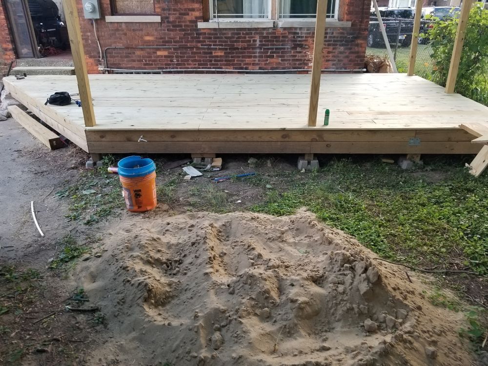A partially built wooden deck in a backyard setting