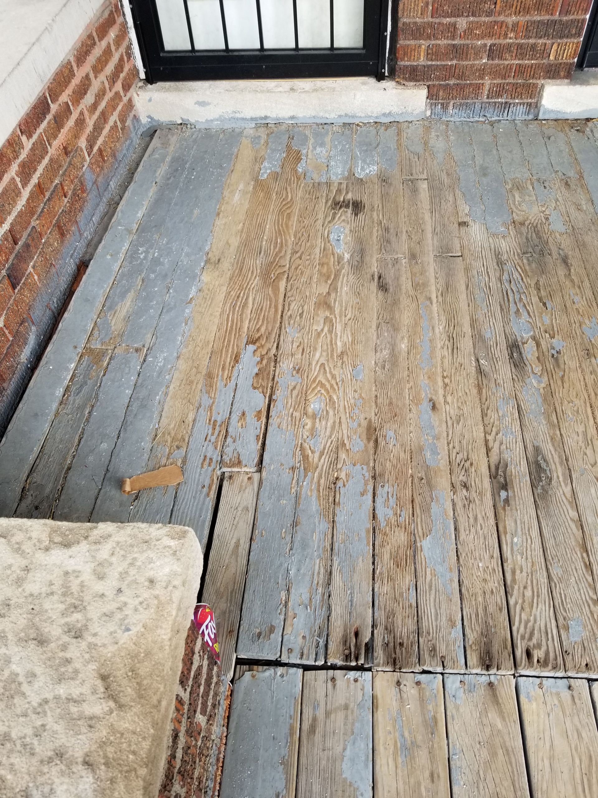 Wooden porch with peeling paint and damaged planks