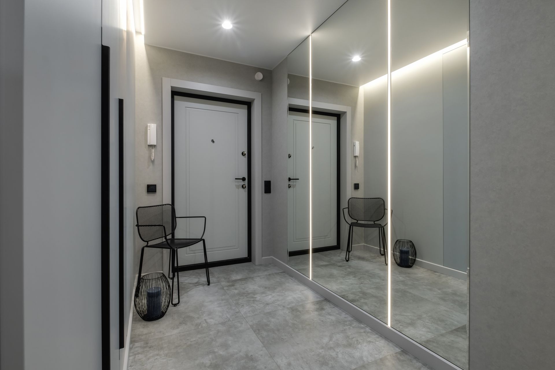 A modern hallway with a full-length mirror gray walls