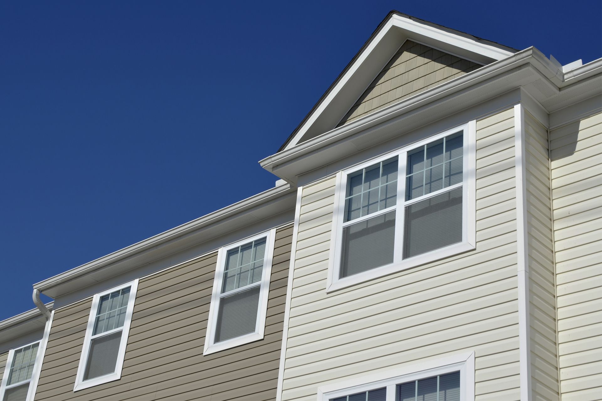 Multi-story building with beige and brown insulated siding