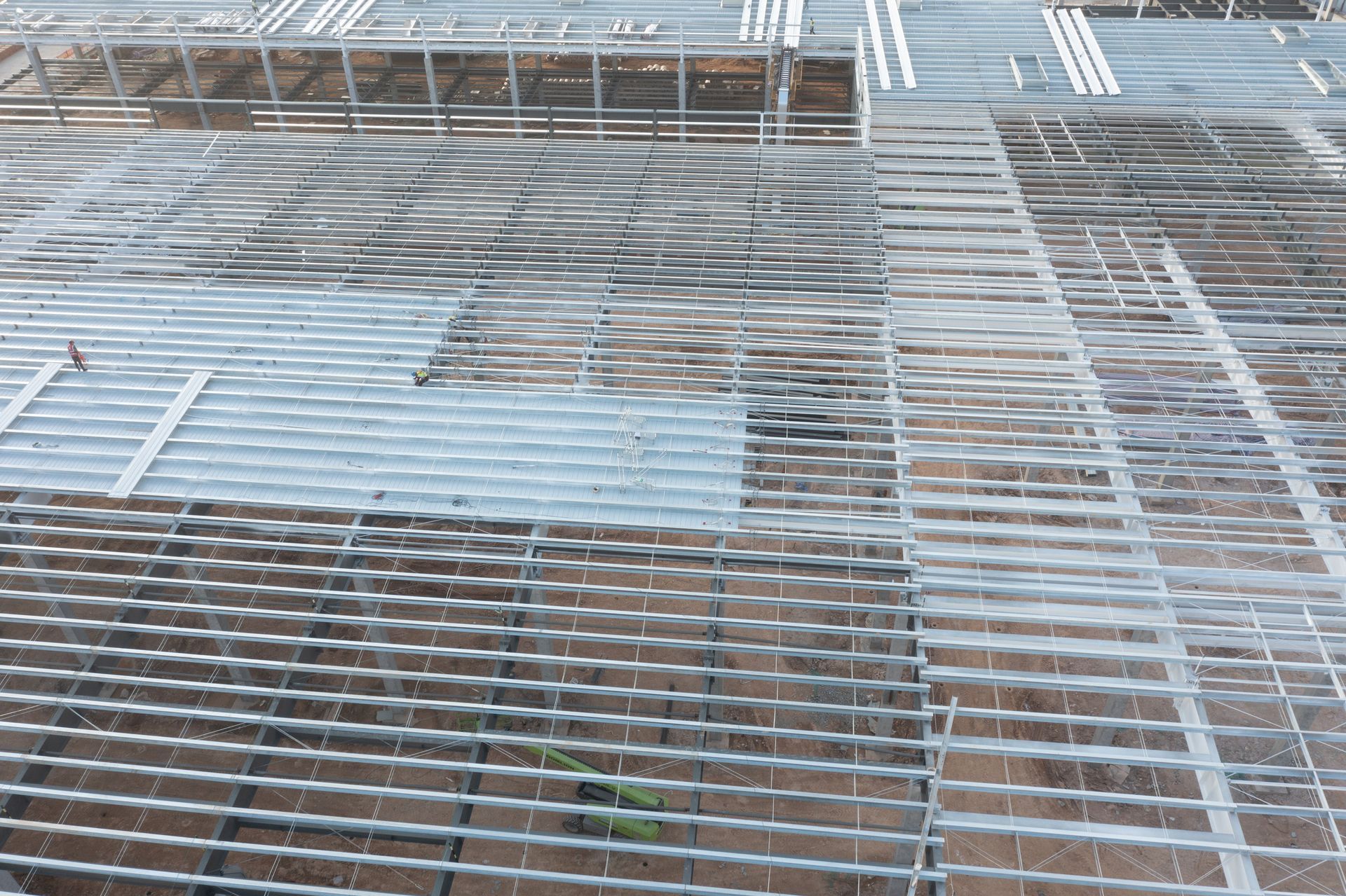 Steel grating floor of a building, with parallel metal bars creating a grid pattern, outdoors.