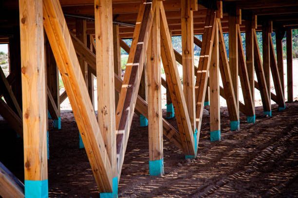 Wooden support beams under a structure, teal paint at the base.