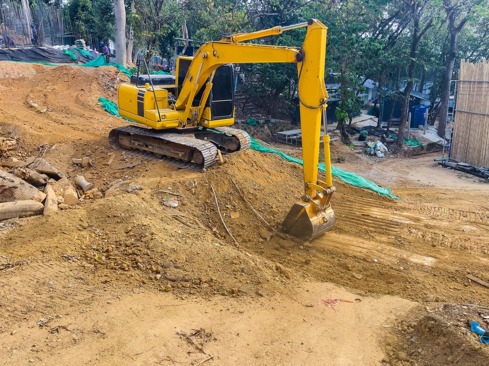 Yellow excavator digging dirt on a construction site.