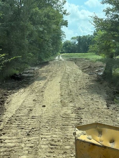 Asphalt driveway with wood borders, leading to a garage entrance.