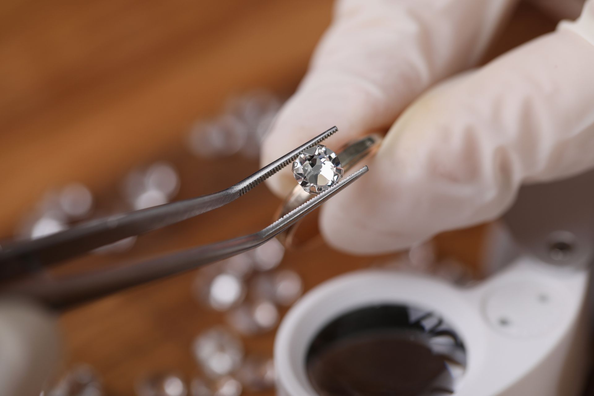 A round diamond clamped by tweezers.