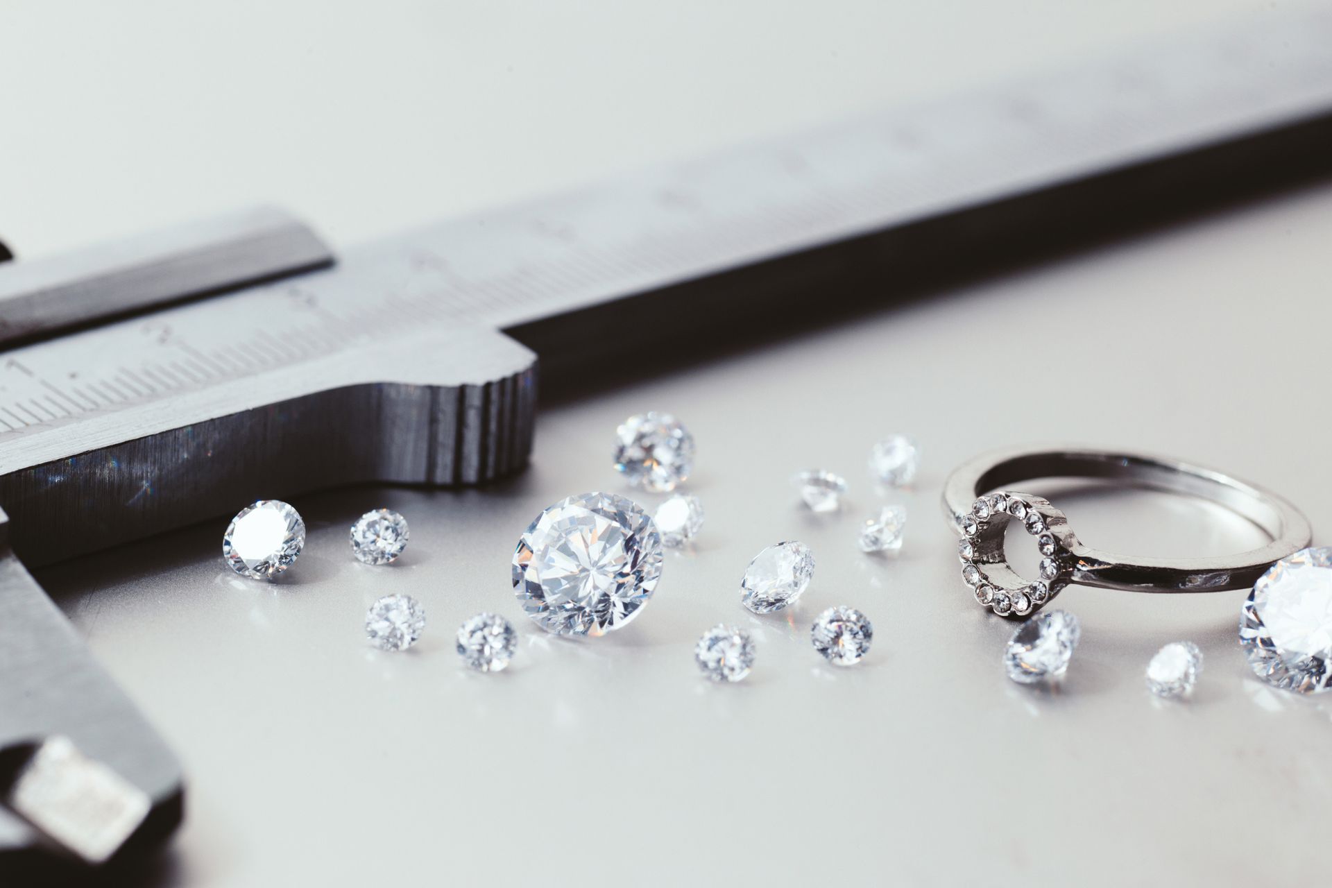 A table showcases a measuring tape next to dazzling diamonds, illustrating premium diamond jewelry i