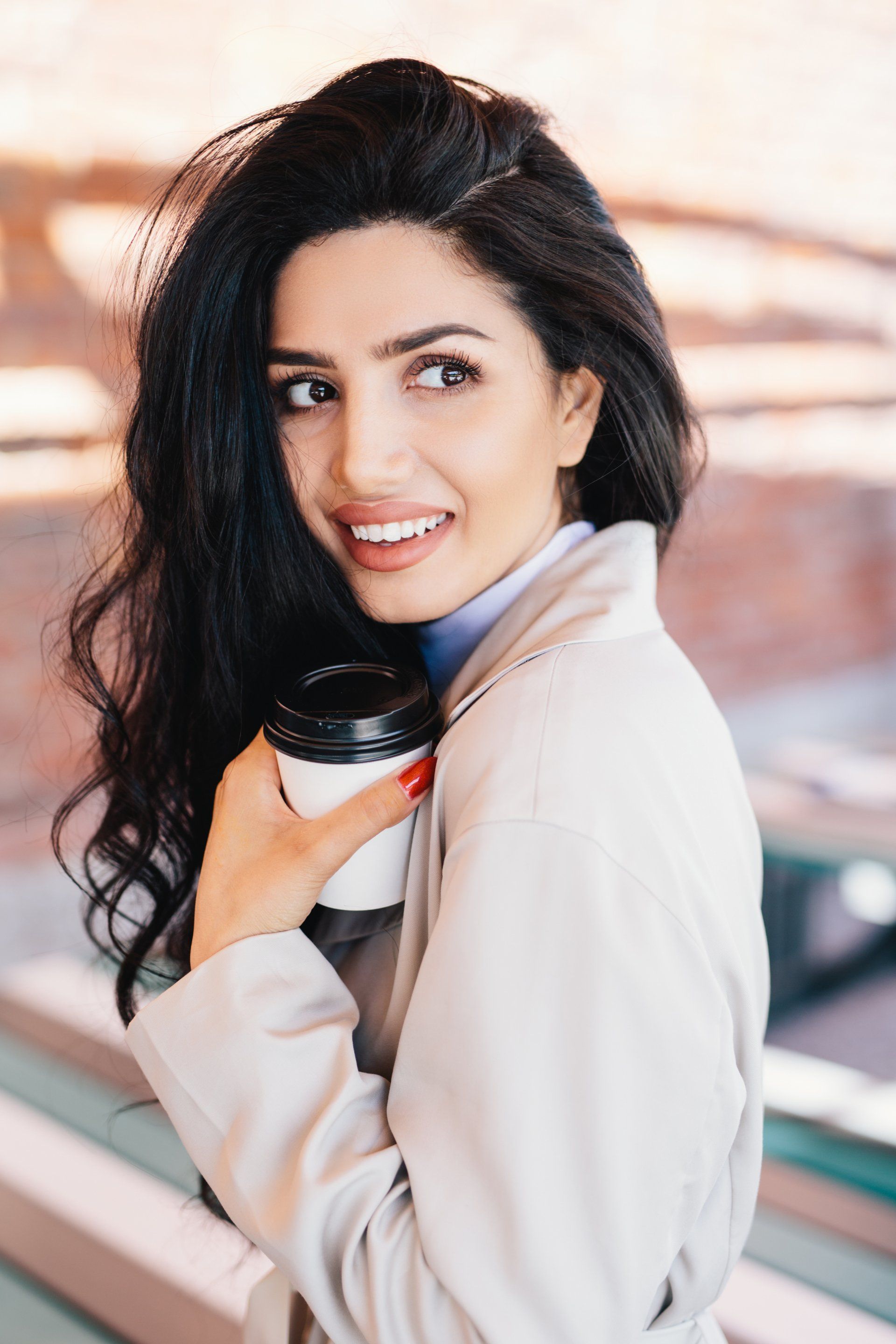 beautiful woman with long black hair holding a coffee