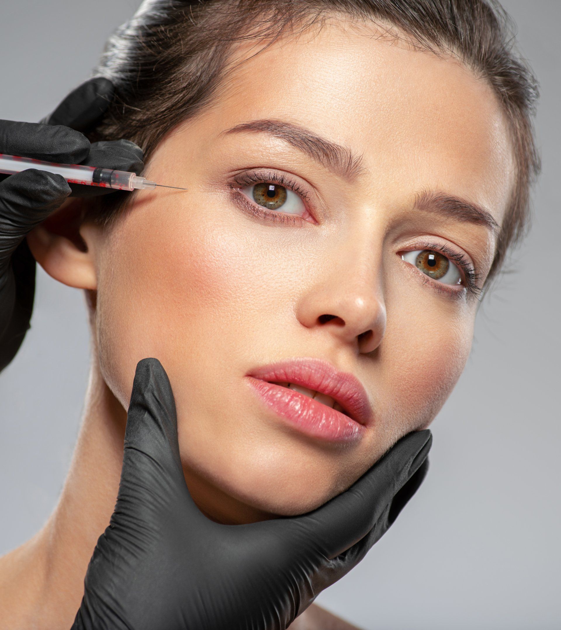 A woman is getting a botox injection in her eye.