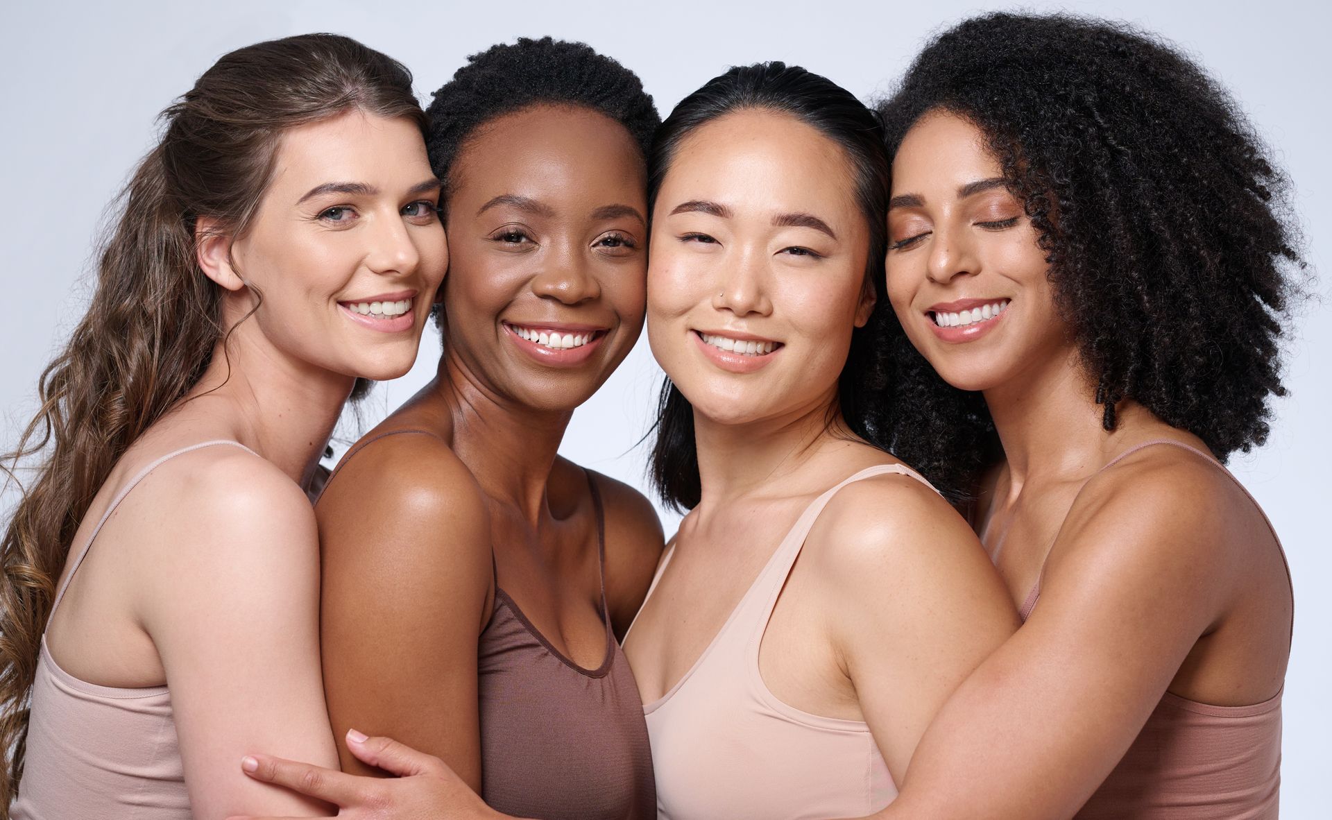 multicultural women smiling in neutral clothing