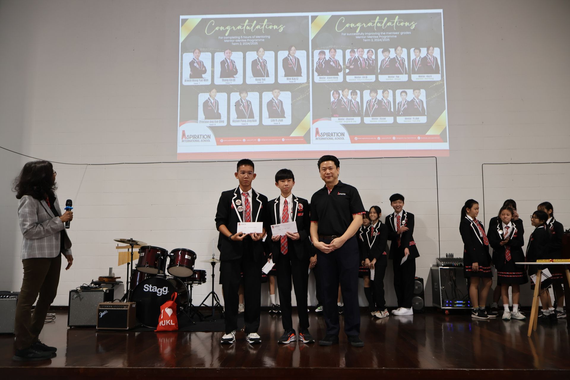 Students receiving awards on a stage, a presentation with a man and other students watching.