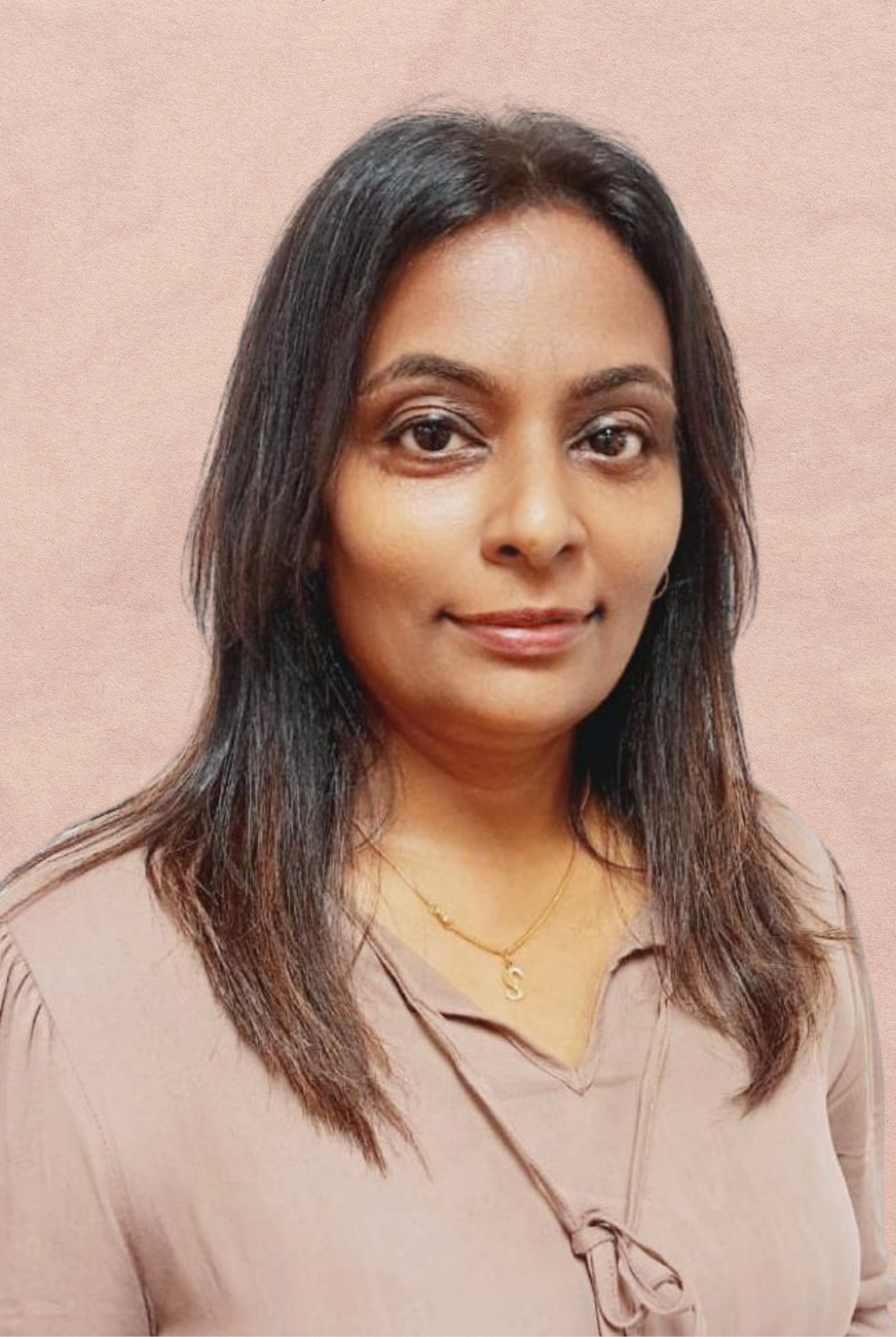 Woman with long dark hair, wearing a beige blouse, smiling slightly, against a pink background.