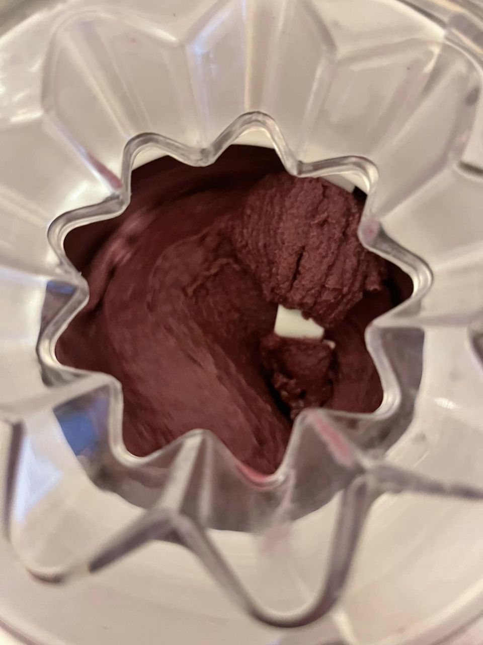 A close up of an ice cream maker with purple ice cream in it