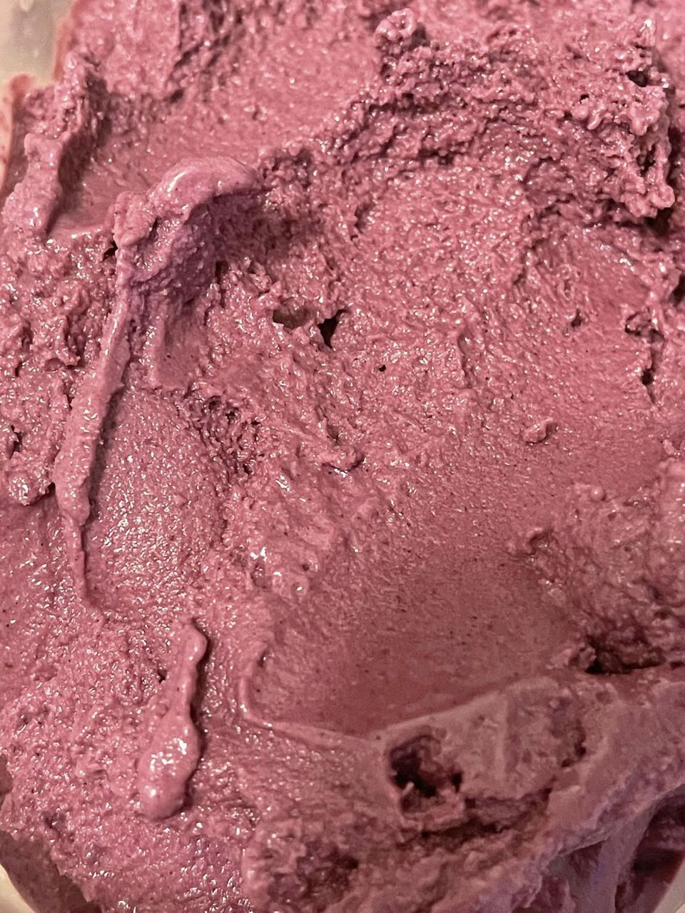 A close up of a purple ice cream scoop in a bowl.