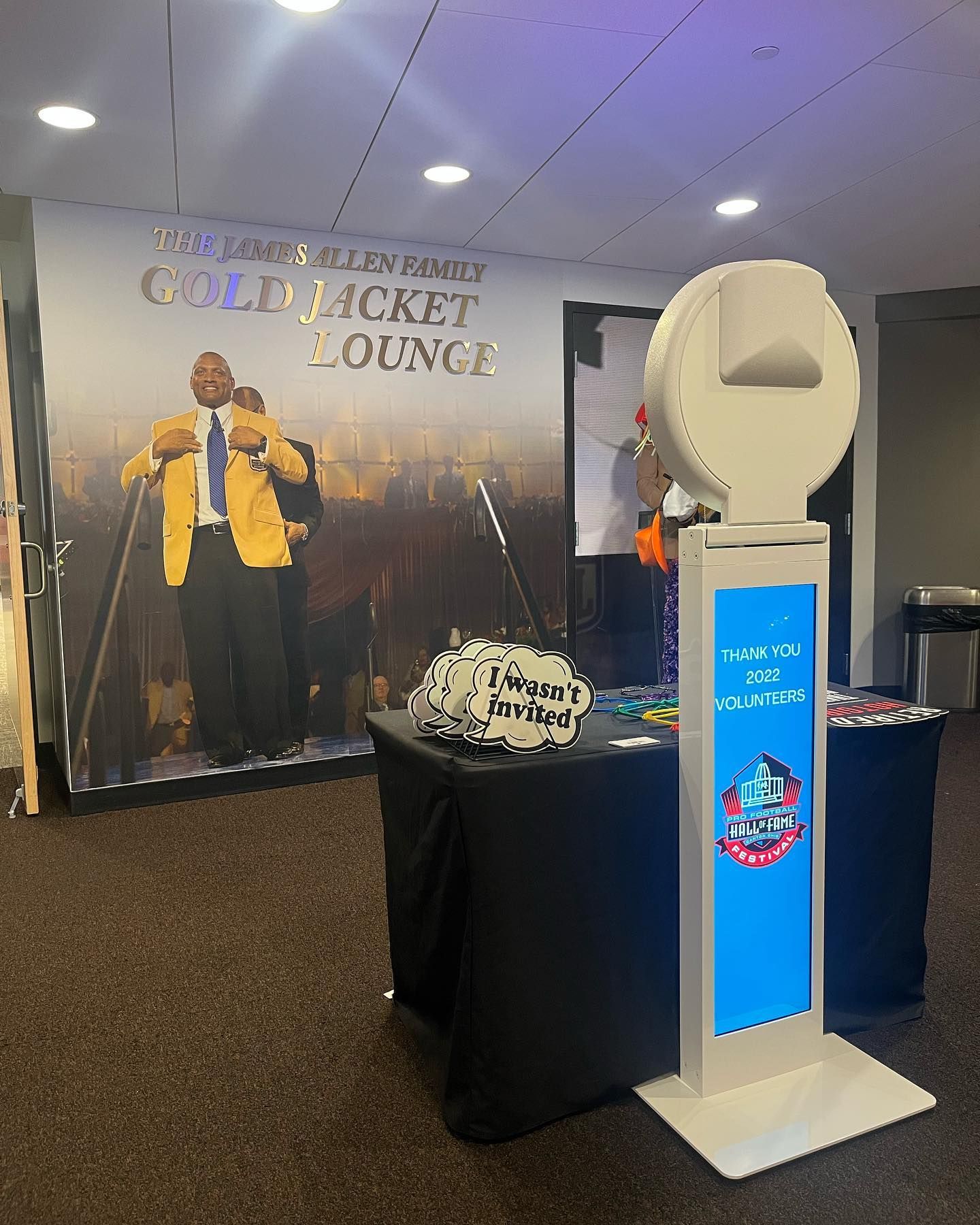 Photo booth set up in the Gold Jacket Lounge with props and backdrop of a man in a gold jacket.