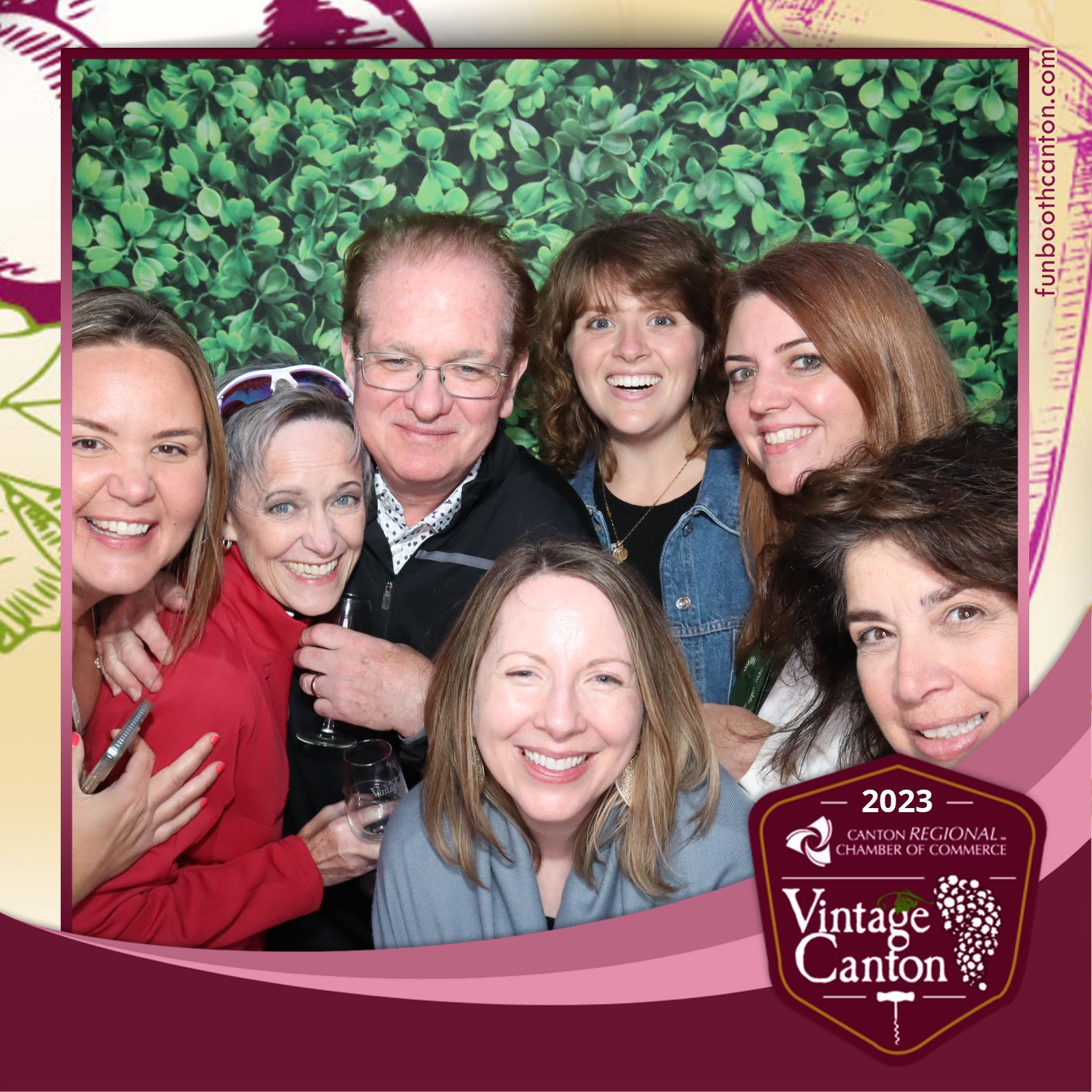 Group of smiling people at a wine event with a 