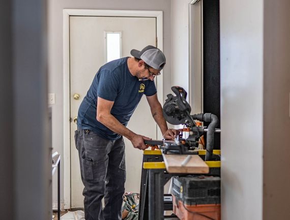 Two men are measuring a cabinet with a level.