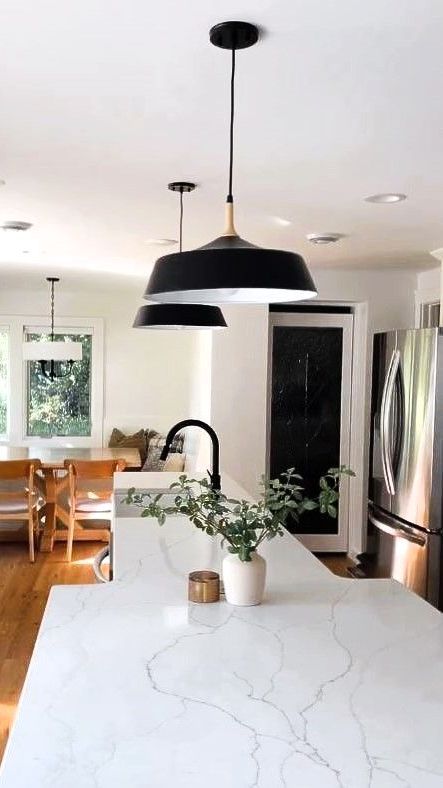A kitchen sink with a gold faucet and a white counter top.