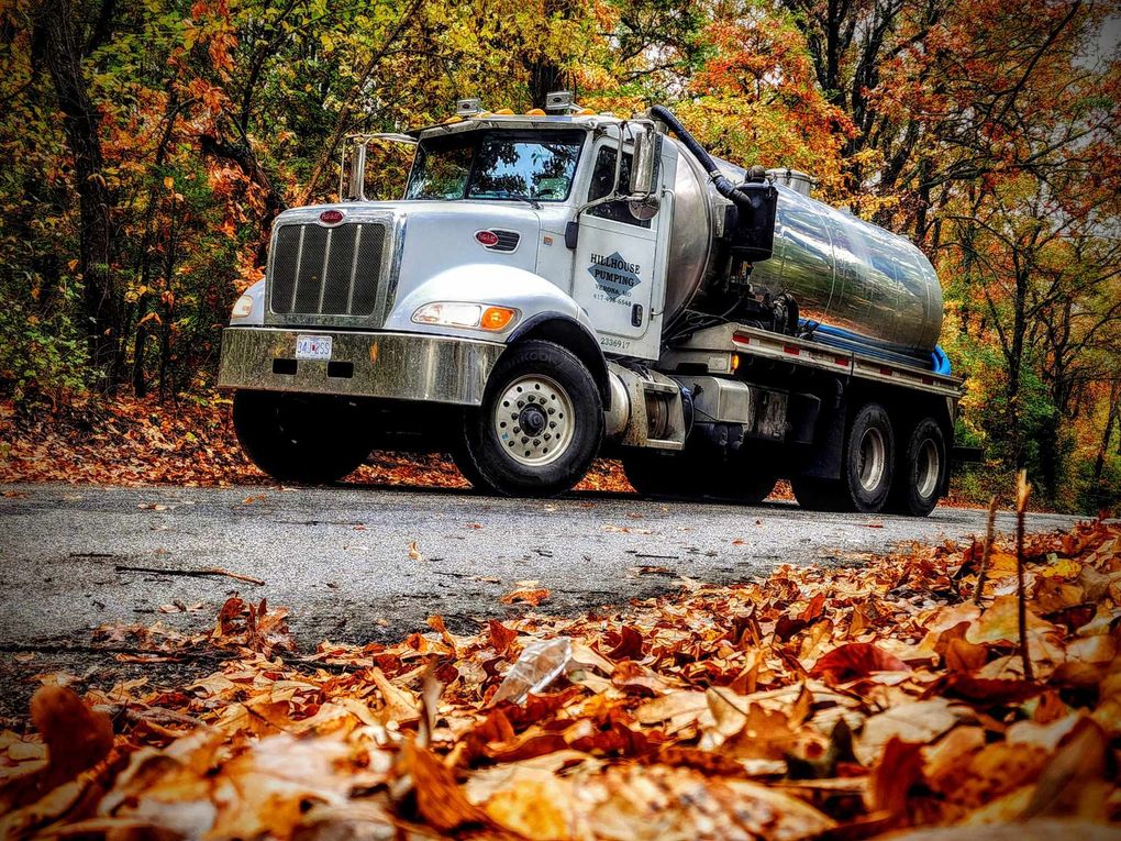 Two semi-trucks, one blue and one white, parked outdoors.