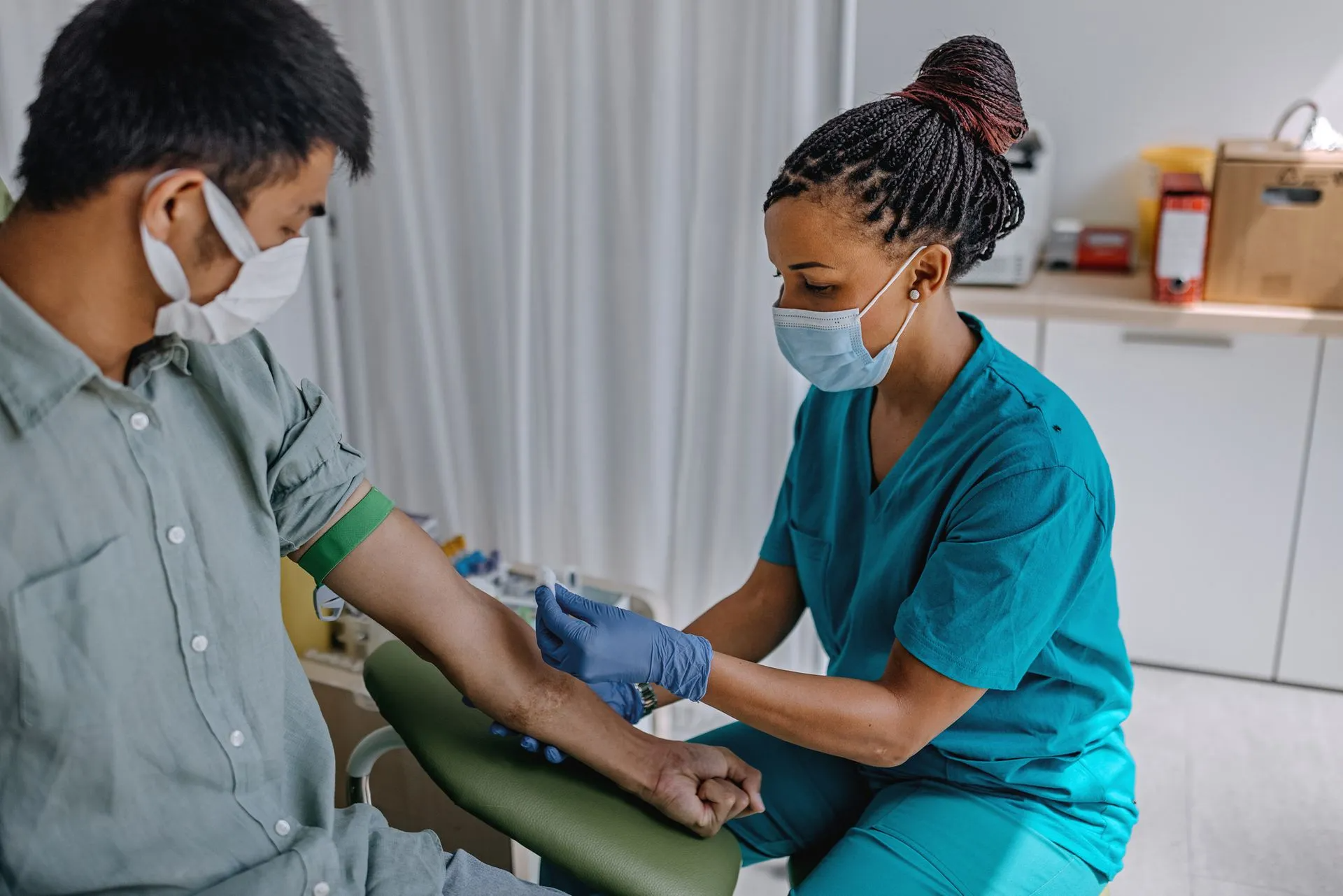 Nurse Drawing Blood from Her Patient