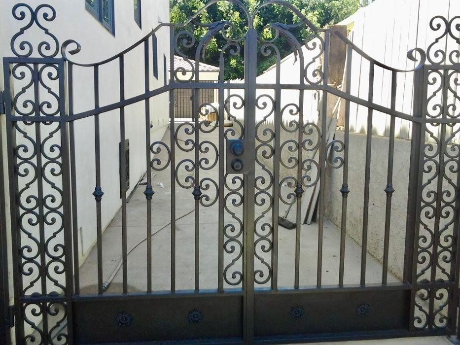 Ornate black and gold gate, topped with an eagle, reads