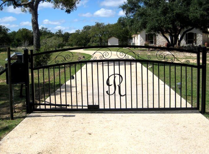 Ornate gate opens to a pink and white palace with a garden