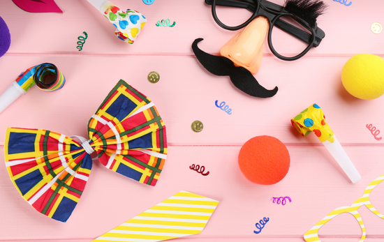 A bunch of clown decorations on a pink wooden table.