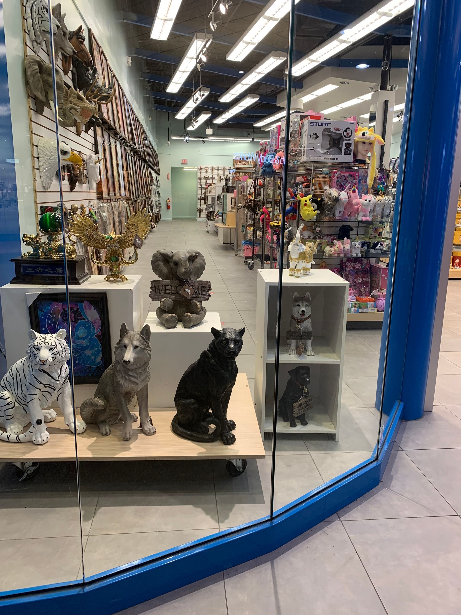 A store window with a lot of statues of animals in it.
