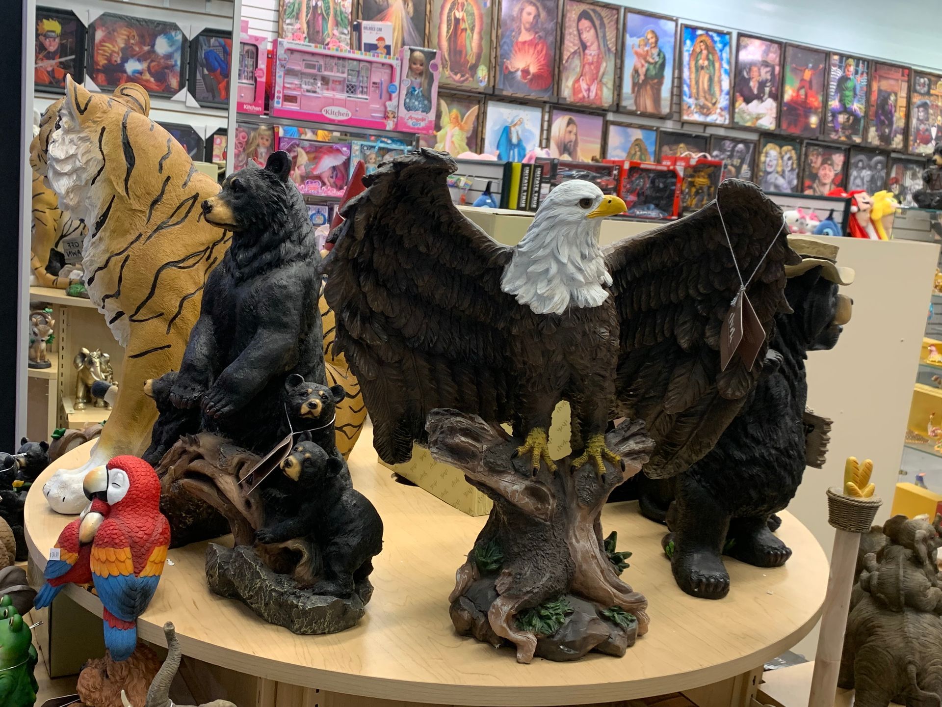 A group of statues of animals are sitting on a table in a store.