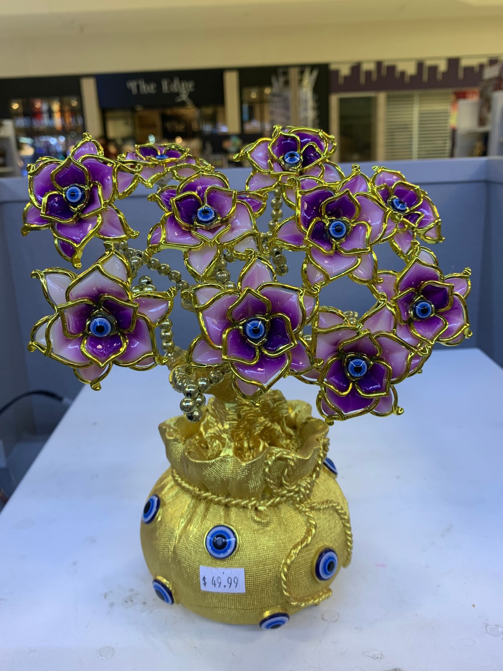 A gold vase with purple flowers on it