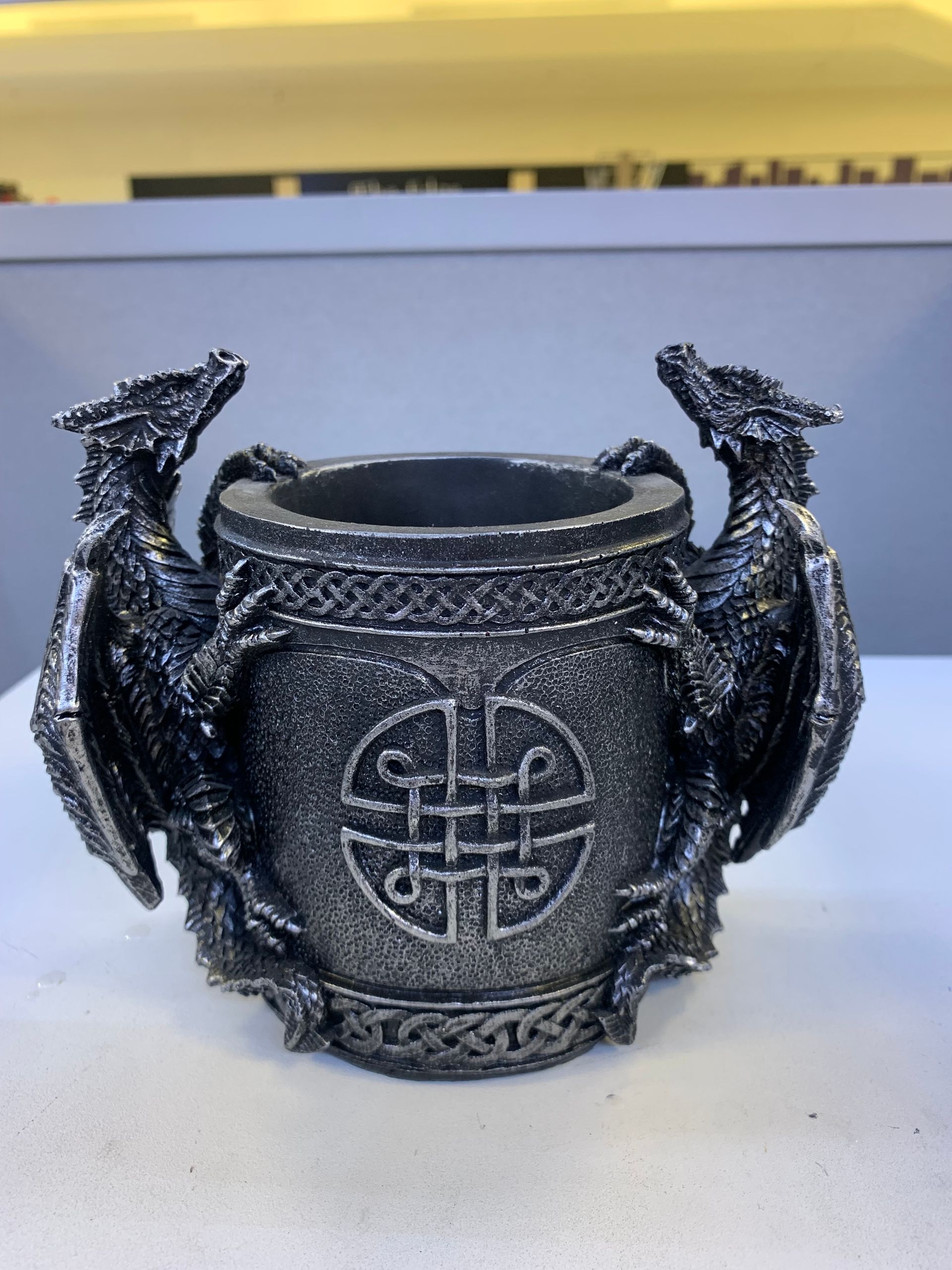 A statue of two dragons with a celtic symbol on it