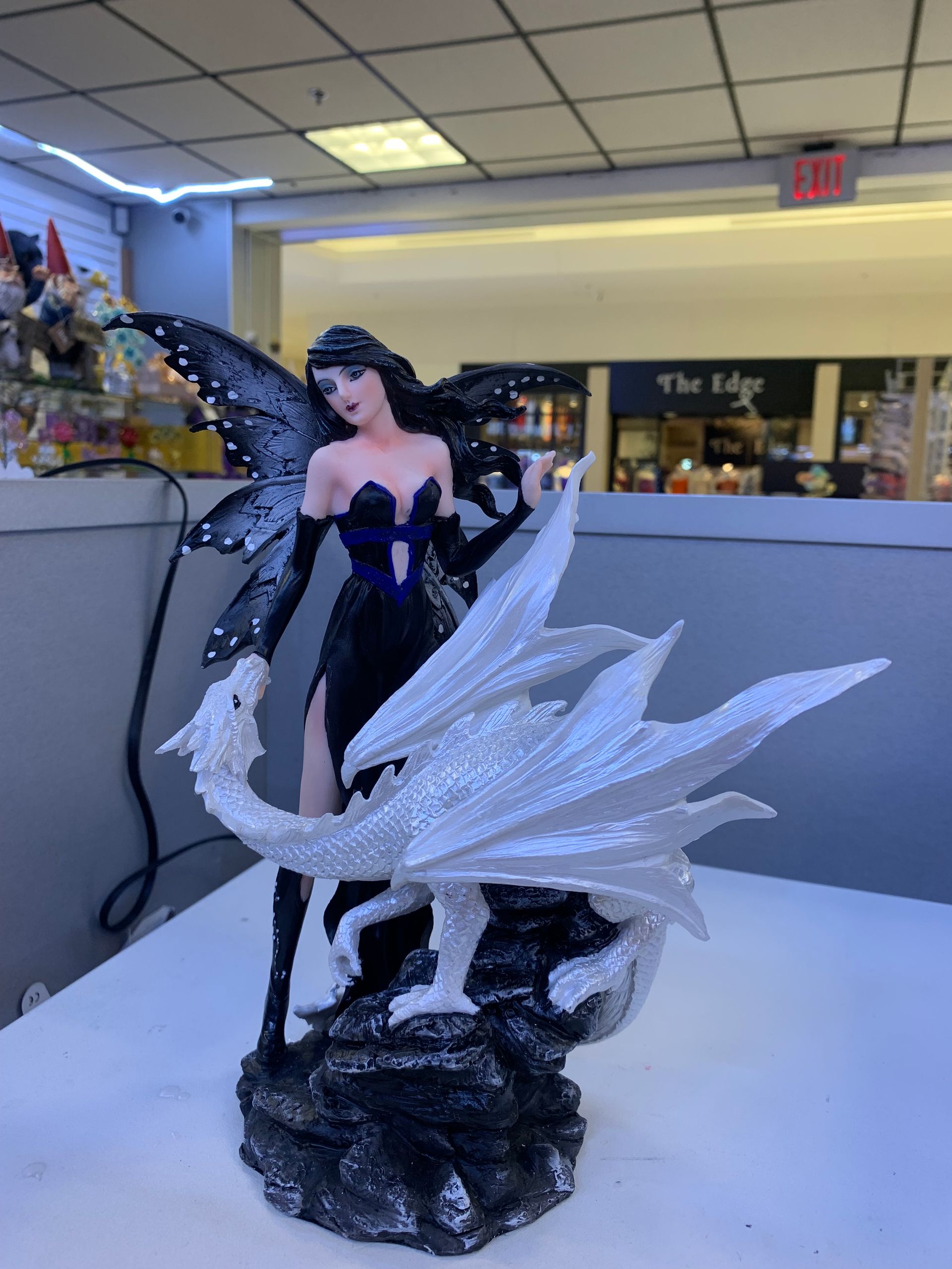 A statue of a fairy holding a white dragon