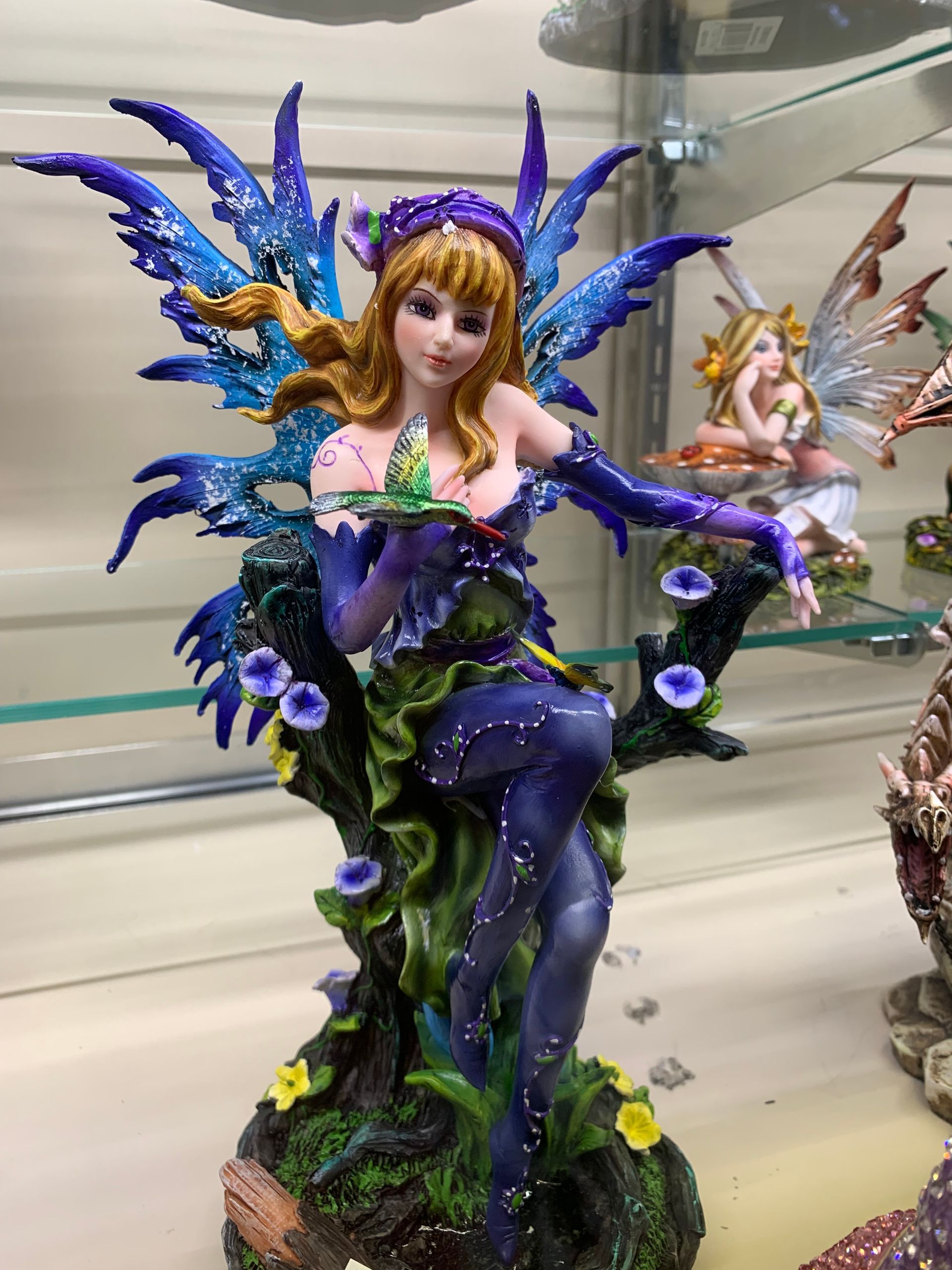 A statue of a fairy sitting on a tree branch