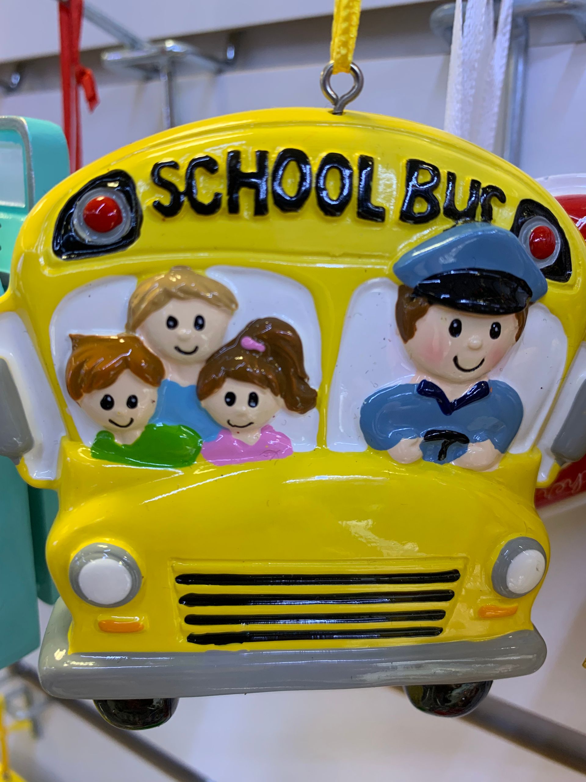 A yellow school bus ornament with children and a police officer