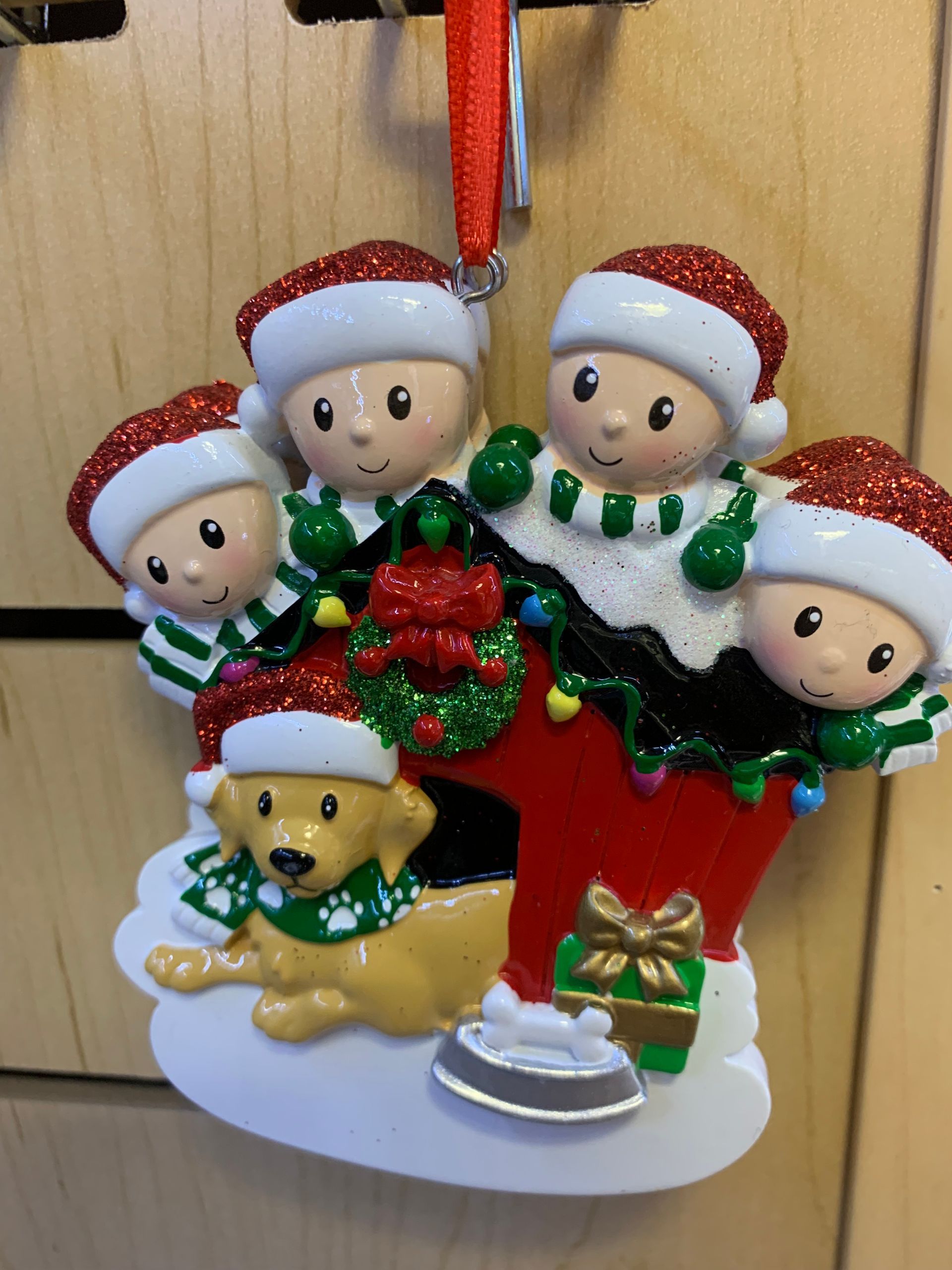 A christmas ornament with four children and a dog