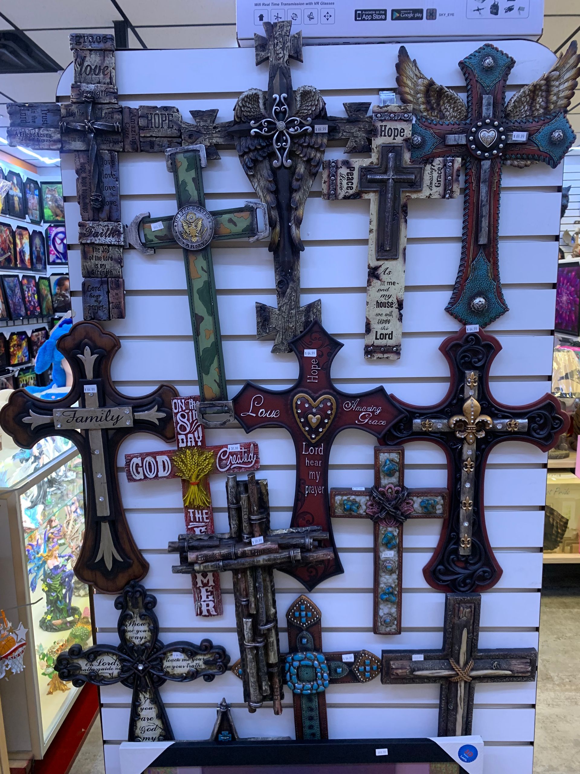 A bunch of crosses are hanging on a wall in a store