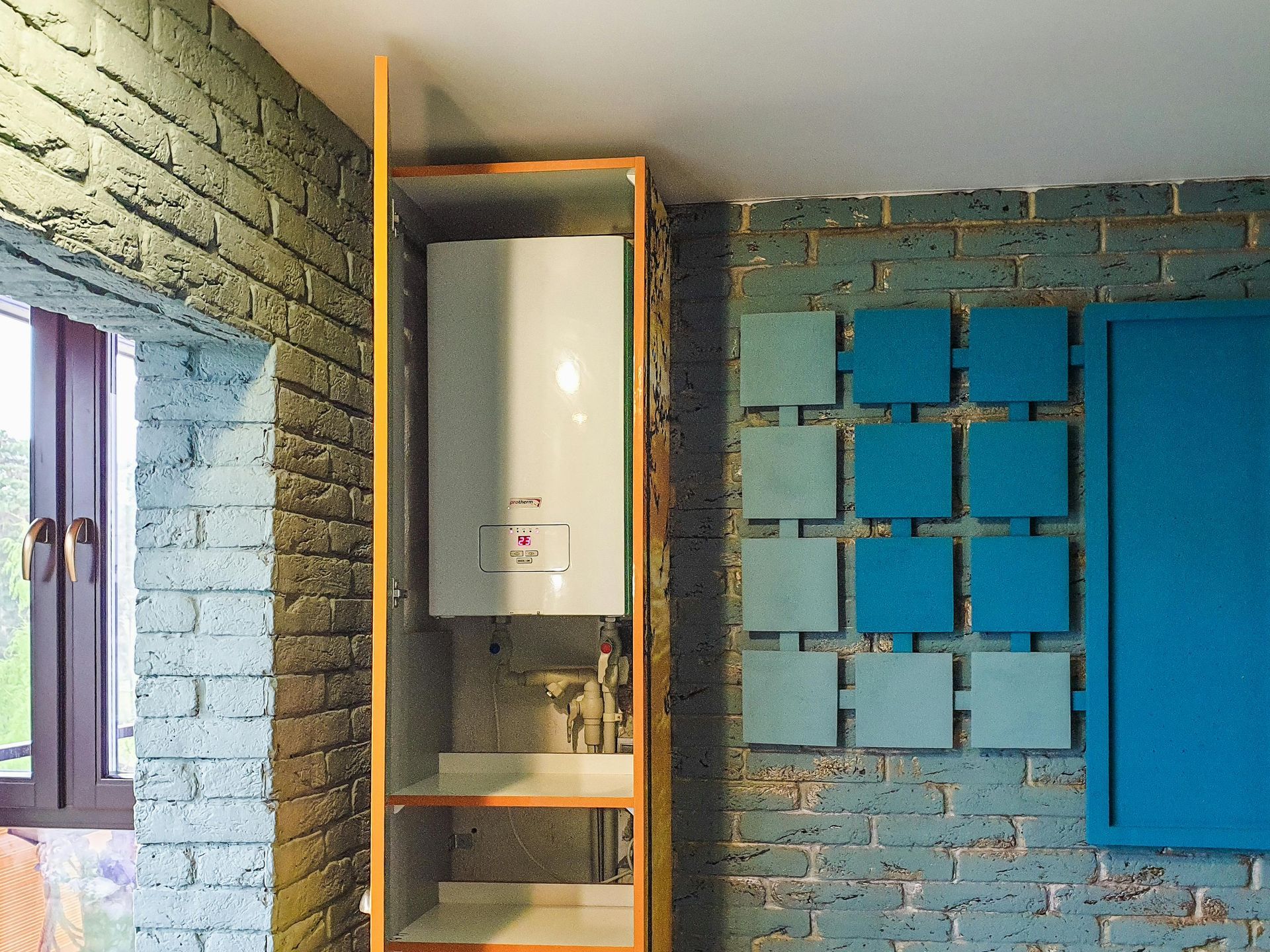 A room with a brick wall and blue squares on the wall