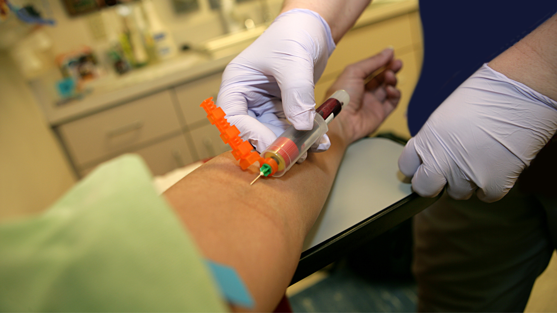 A person receiving a vaccination in their arm at a healthcare facility.