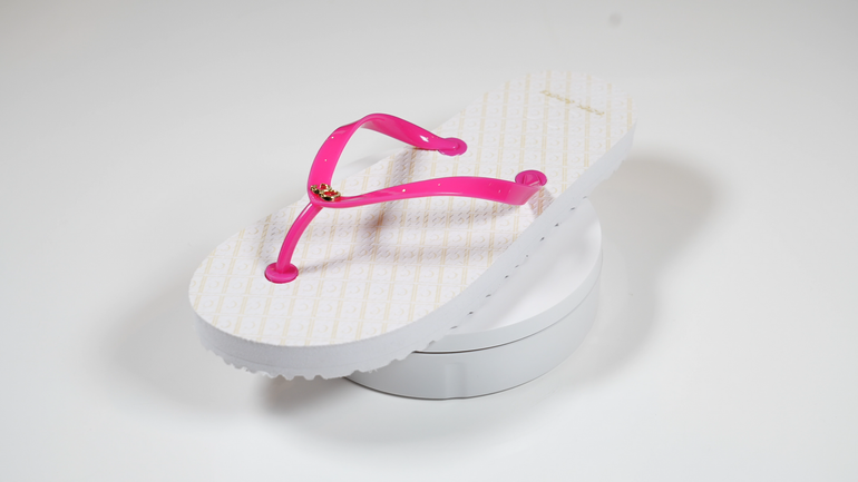A pair of white flip flops with pink straps
