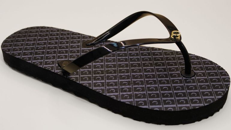 A pair of black flip flops on a white surface