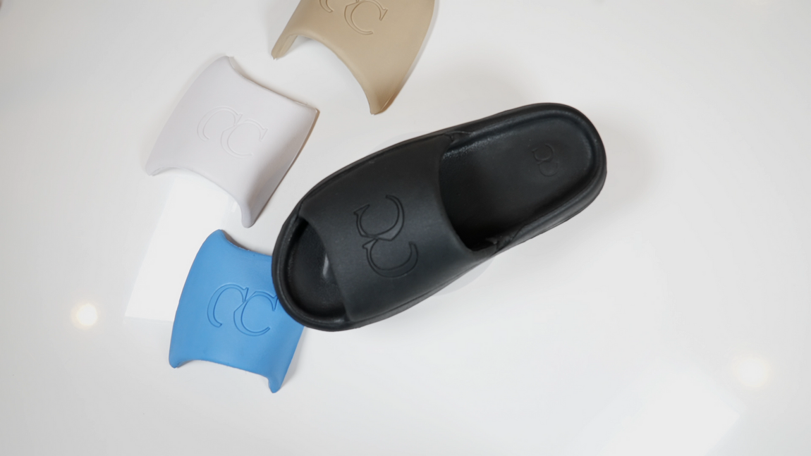A pair of black sandals sitting on top of a white surface.