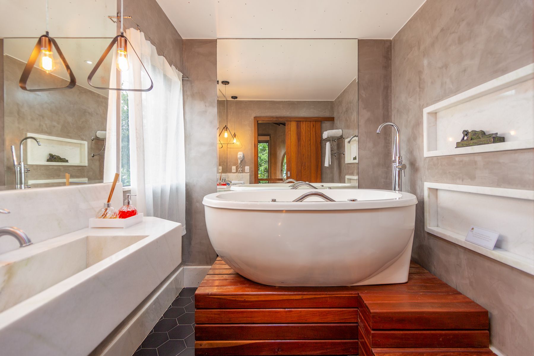 Há uma grande banheira no meio do banheiro.