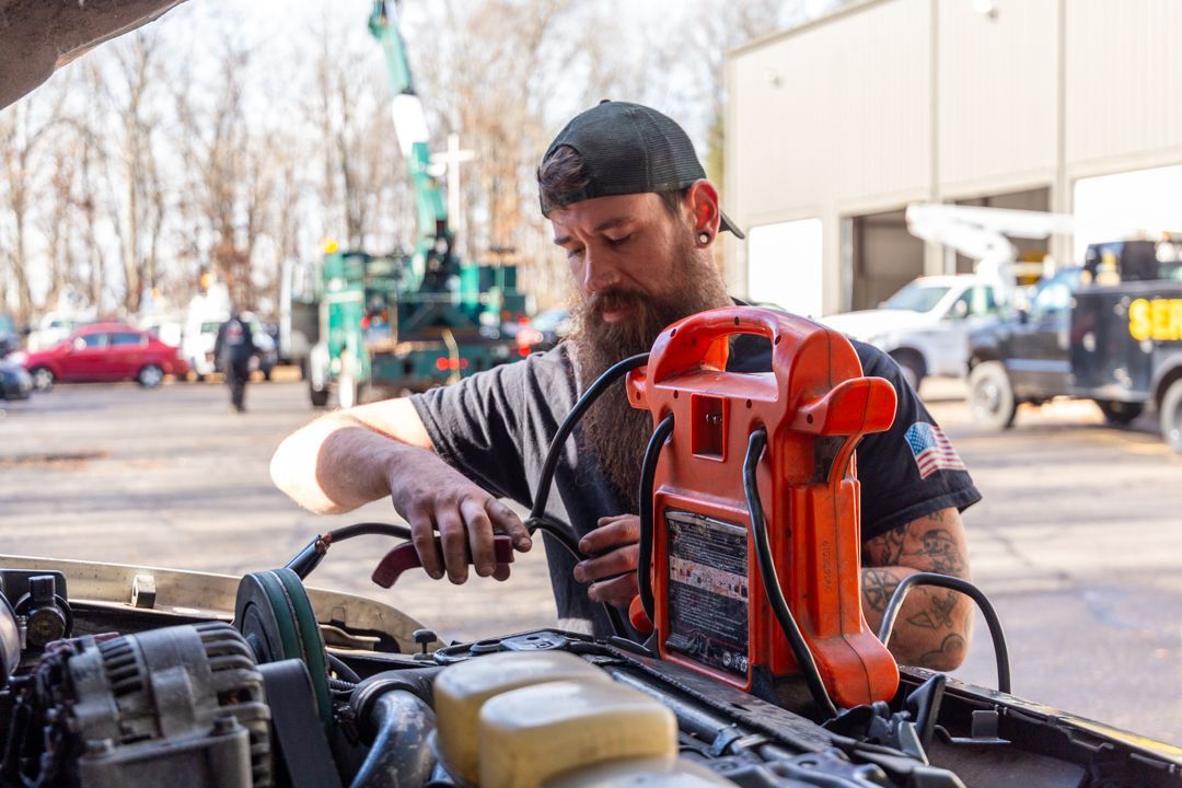 A man is working on a car with a jump starter.