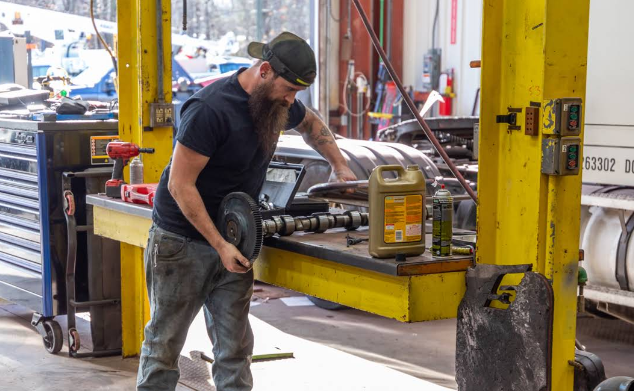 A man is working on a truck in a garage.