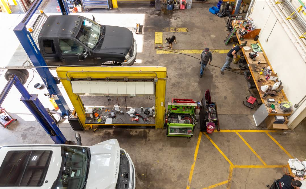 An aerial view of a car repair shop with cars on lifts.